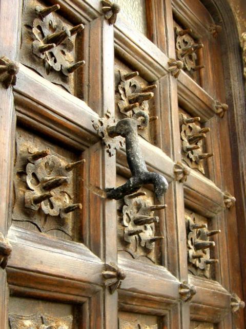 Фрагмент деревянной двери с дверной ручкой в виде собаки
